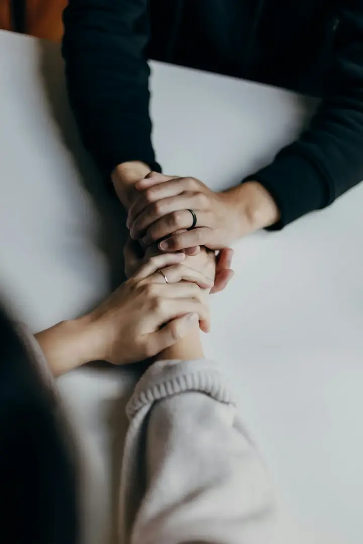 One person supporting another person's hands